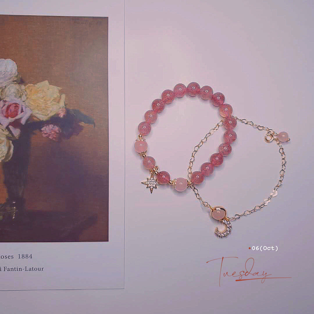 Pink beaded bracelet with gold chain on a light background