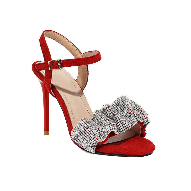 Red high-heeled sandal with a decorative bow on a white background