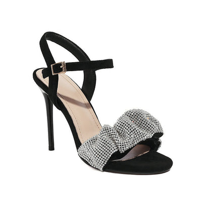 Black high-heeled sandal with a silver bow on a white background