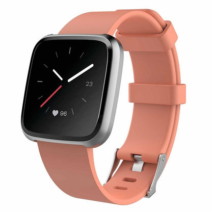 Smartwatch with a peach-colored band on a white background