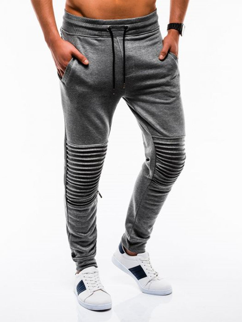 Gray jogger pants with zippers on a white background