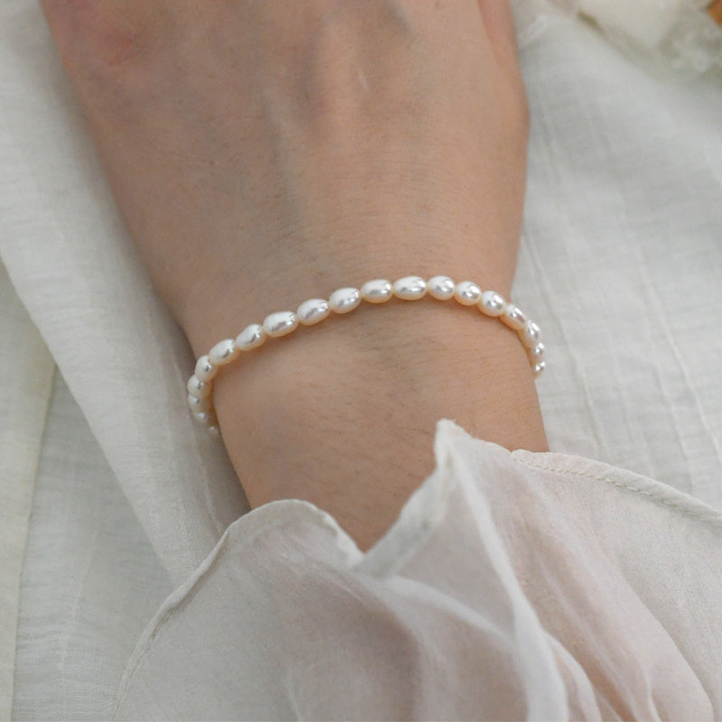 Pearl bracelet on a wrist with a soft white background