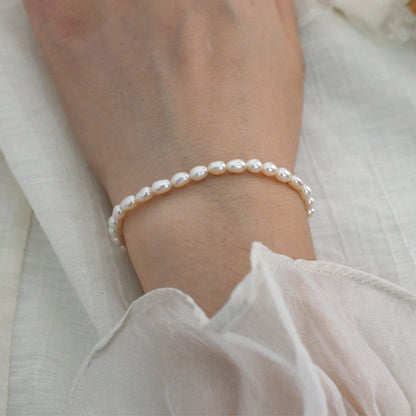 Pearl bracelet on a wrist with a soft white background
