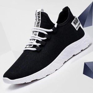 Black running shoes with white soles on a light gray background
