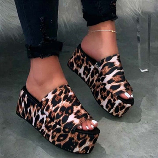 Leopard print platform sandals worn on a neutral background