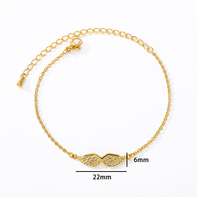 Gold bracelet with angel wing design on a white background