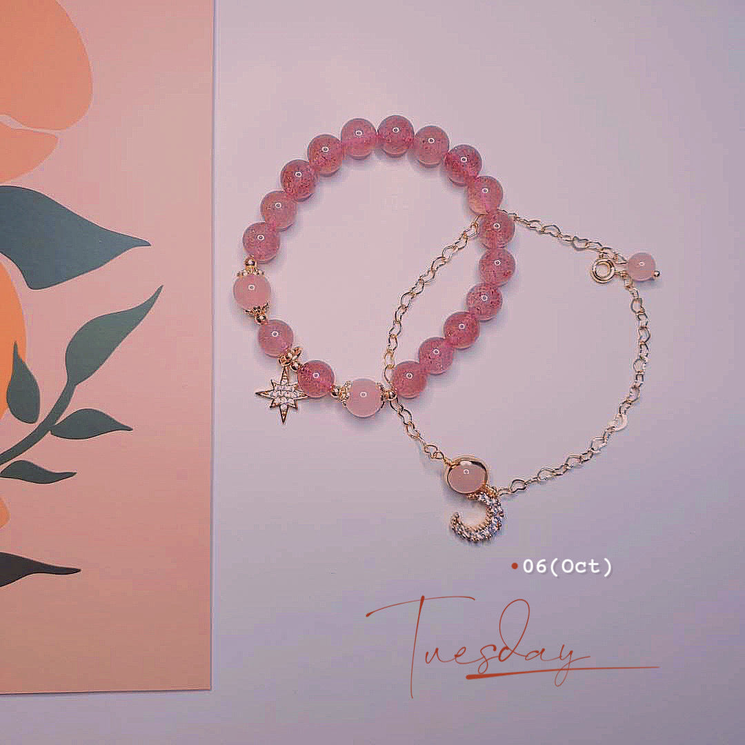 Pink beaded bracelet with charms on a light pink background