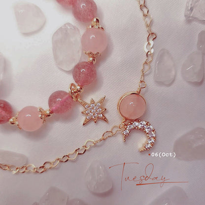 Necklace with pink beads and charms on a light pink background