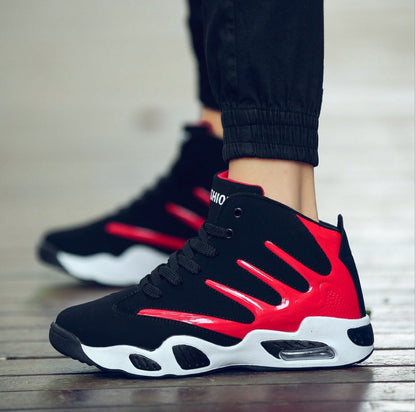 Black and red sneakers with white soles on a wooden floor.