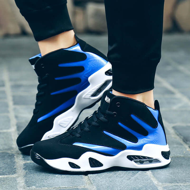 Black and blue sneakers with white soles worn on a paved surface