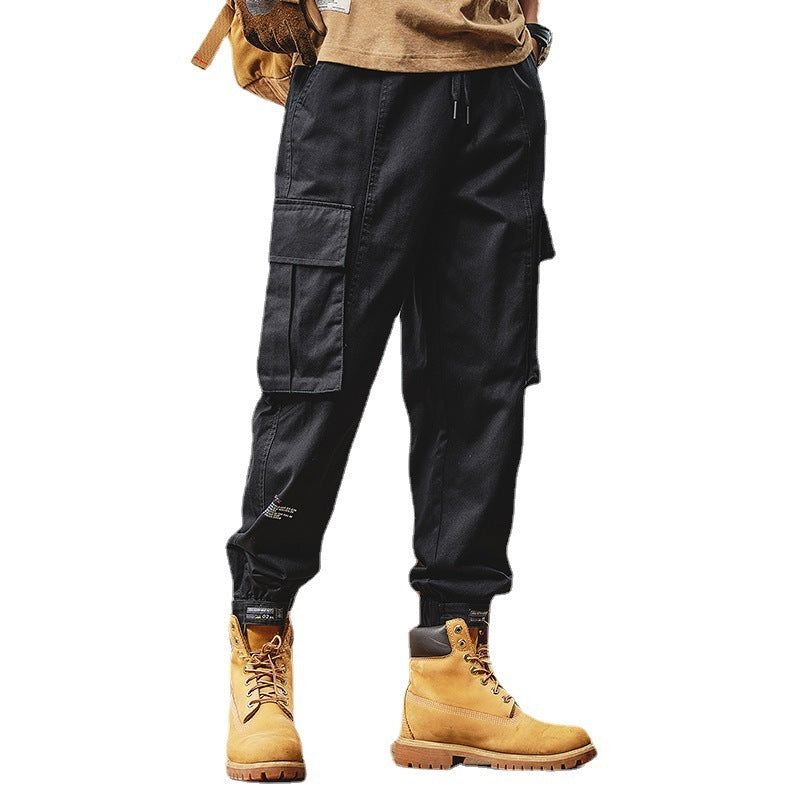 Black cargo pants with beige boots on a white background