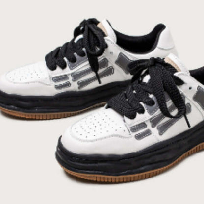 White sneakers with black and brown accents on a light gray background