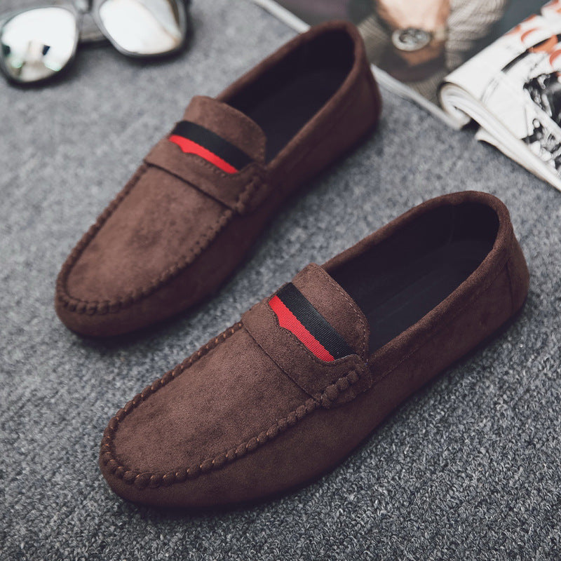 Brown loafers with red and black accents on a gray surface