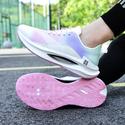 White and pink running shoes on a black surface with greenery in the background