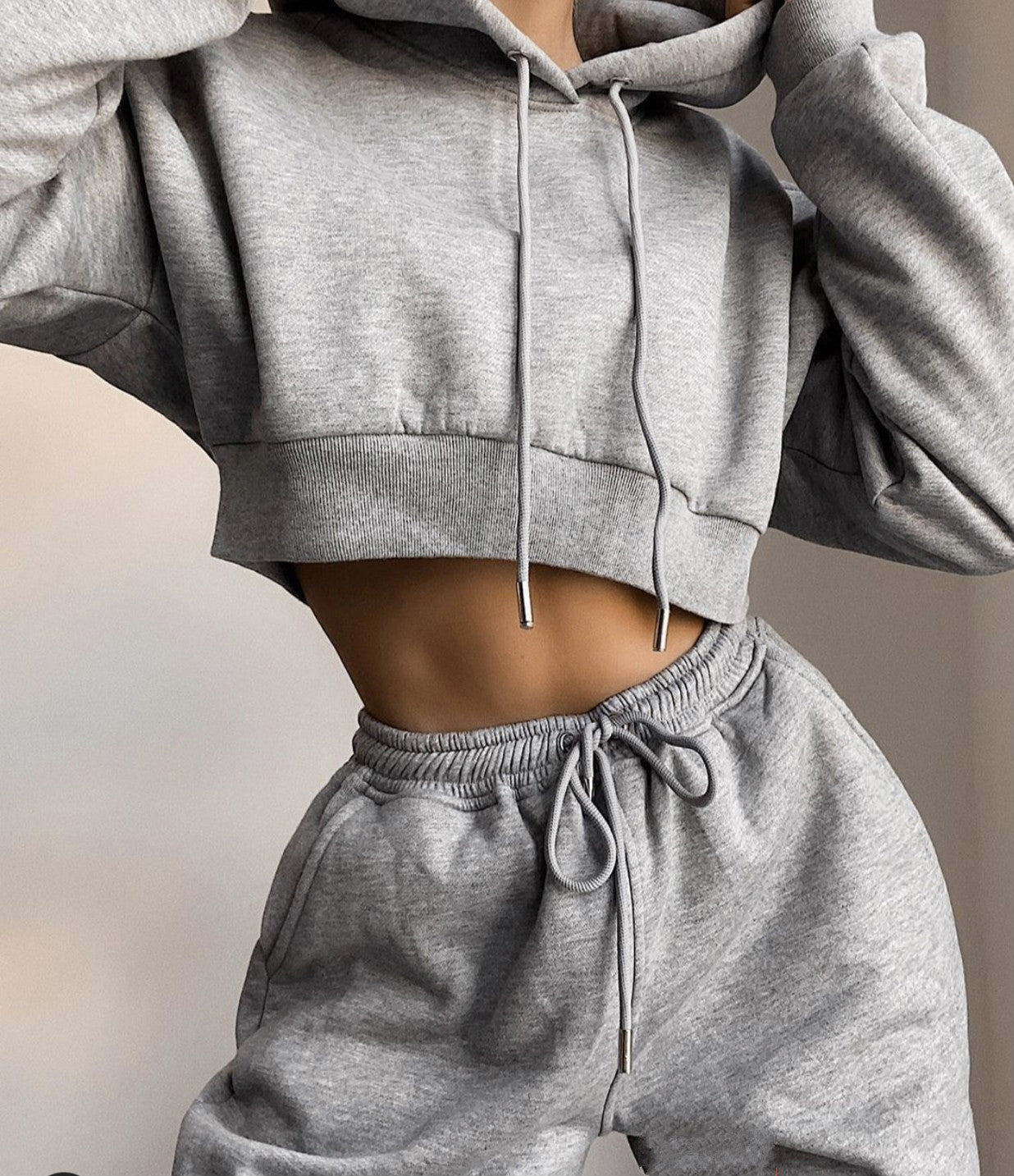 Gray hoodie and sweatpants set on a neutral background