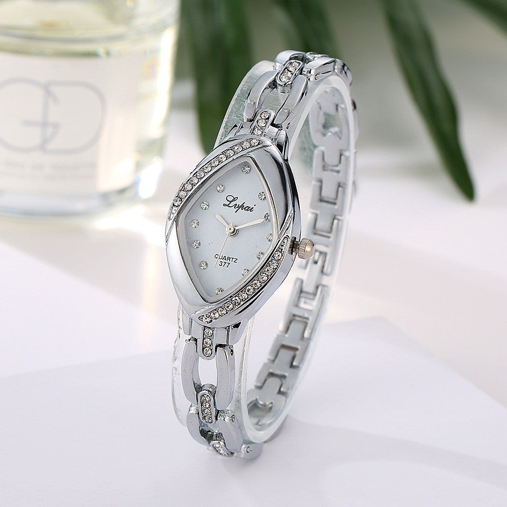 Silver wristwatch with decorative band on a white surface