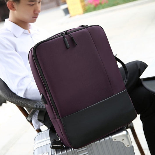 Purple backpack on a suitcase with a blurred background