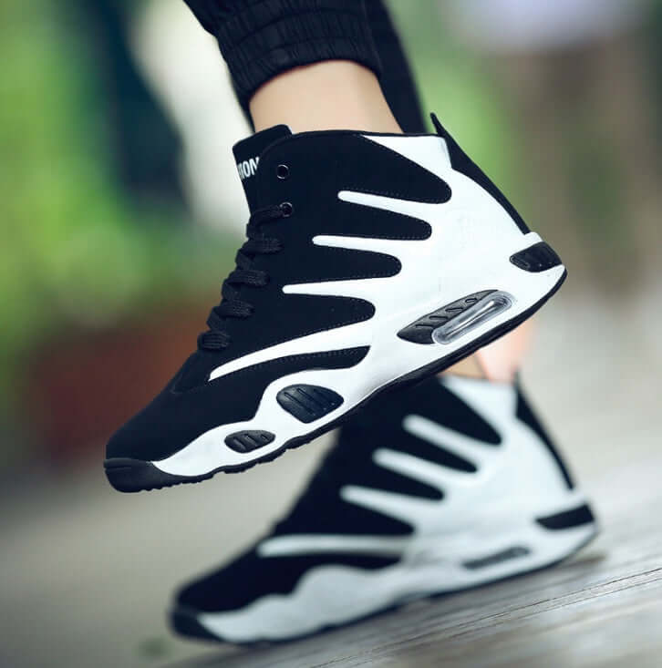 Black and white sneakers with visible brand logo on a blurred background