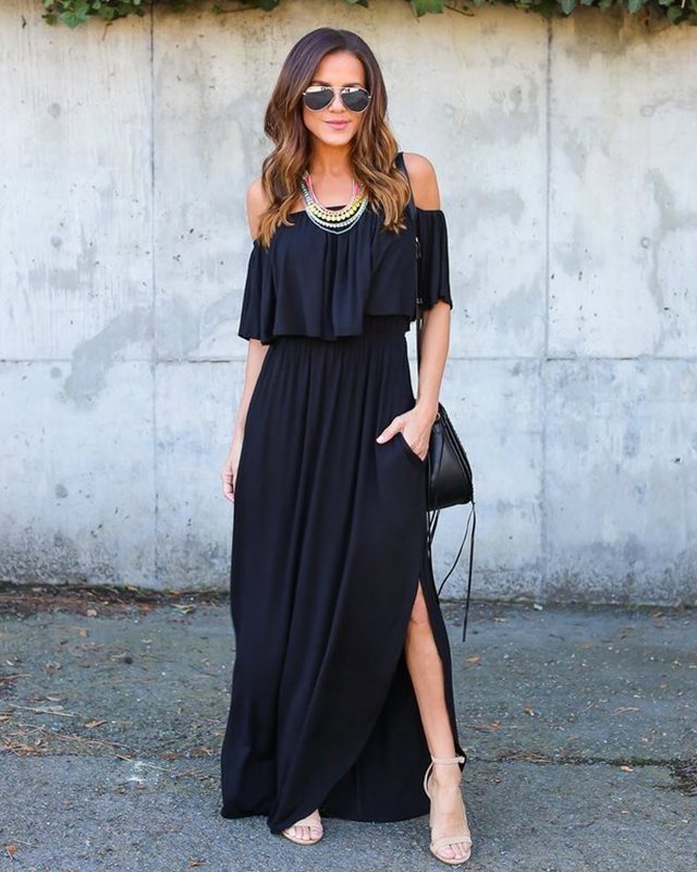 Woman wearing a black off-shoulder dress with a gray wall background