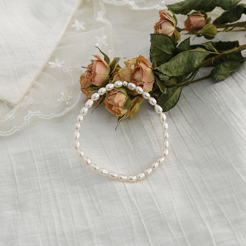 Pearl headband with flowers on a textured white surface