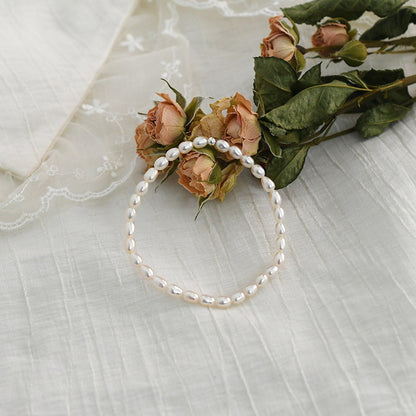 Pearl headband with flowers on a textured white surface