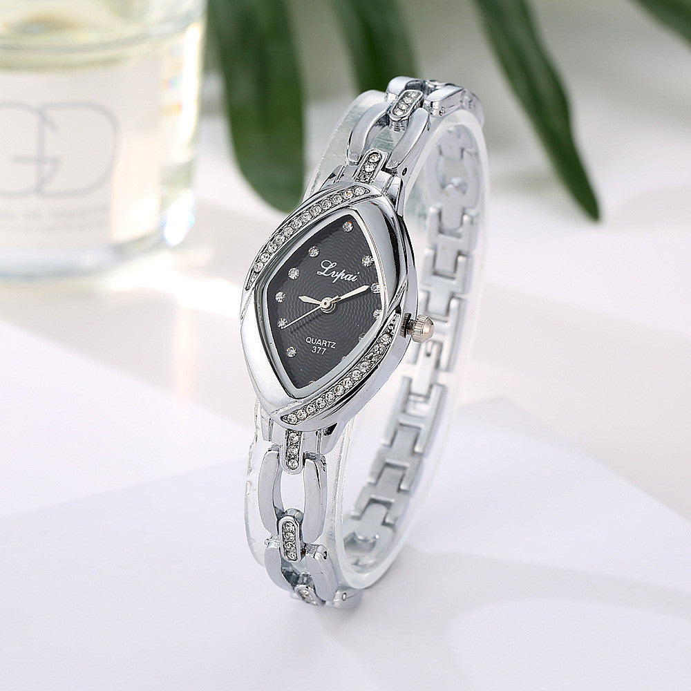 Silver wristwatch with black face on a white surface