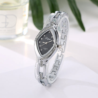 Silver wristwatch with black face on a white surface