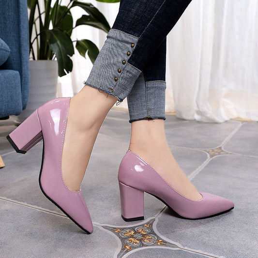 Person wearing pink high-heeled shoes on a tiled floor.