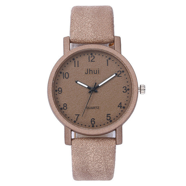 Beige wristwatch with a round face and textured strap on a white background