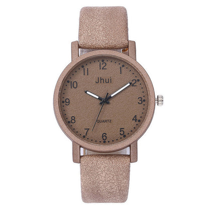 Beige wristwatch with a round face and textured strap on a white background