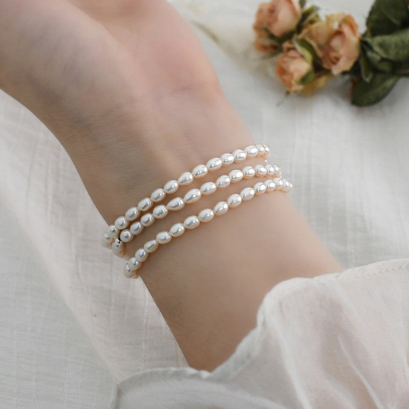Three pearl bracelets on a wrist with a soft background