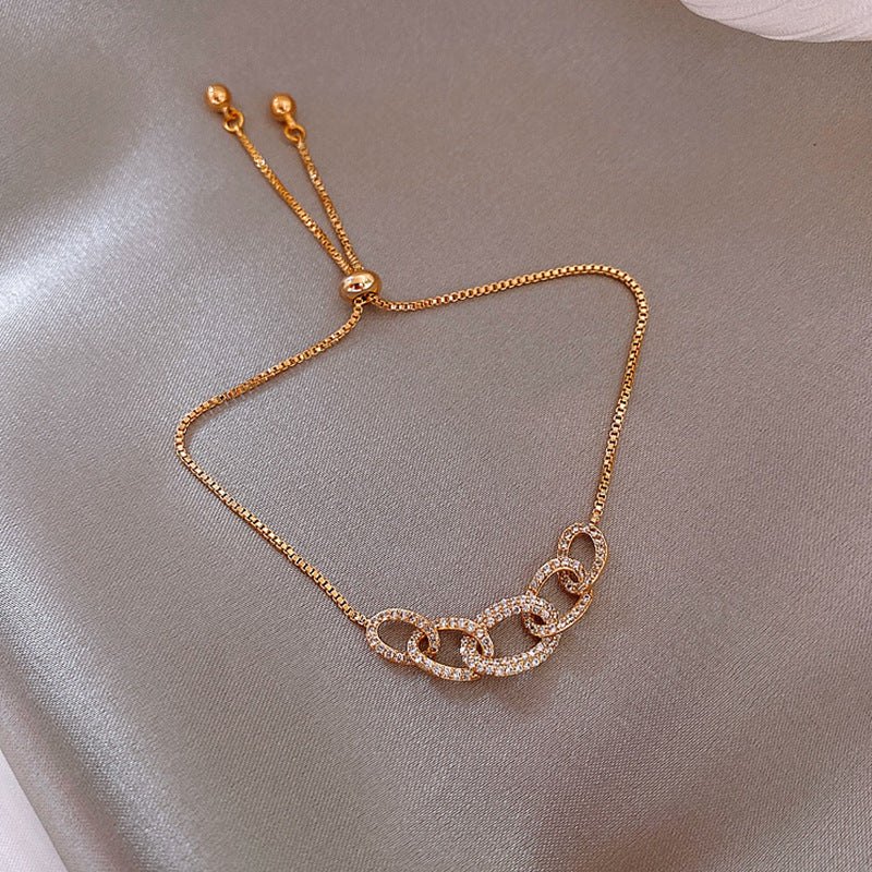 Gold chain bracelet on a soft gray background
