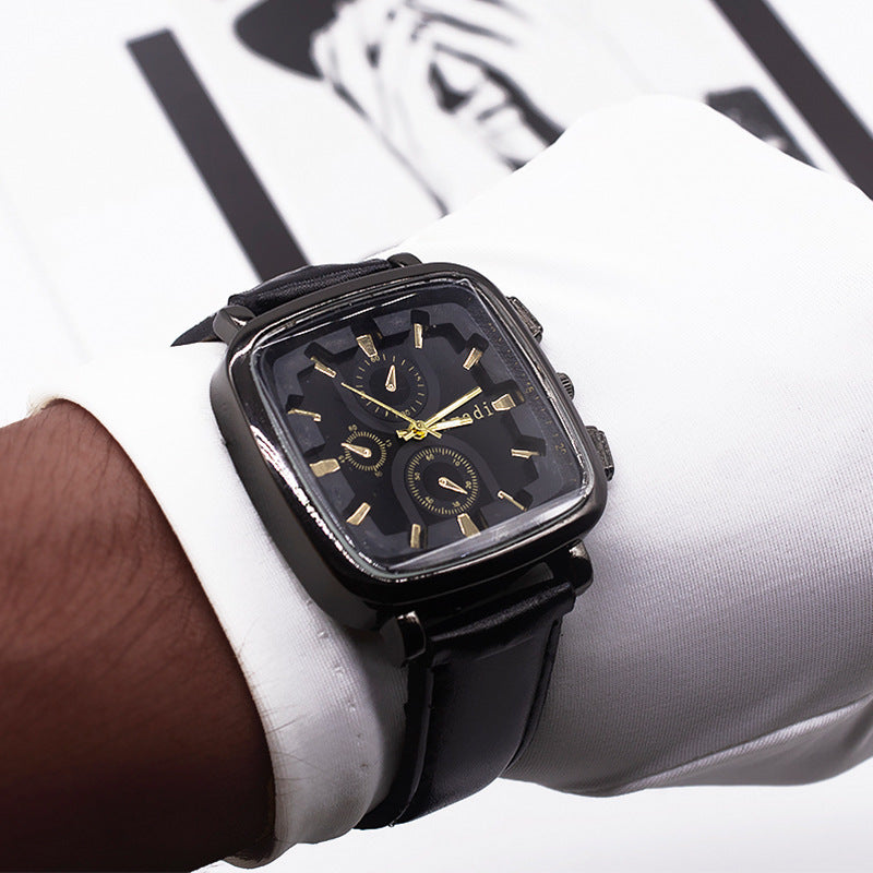 Black wristwatch with gold accents on a person's wrist, wearing a white shirt.