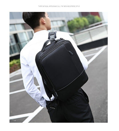 Person wearing a black backpack outdoors on a street.