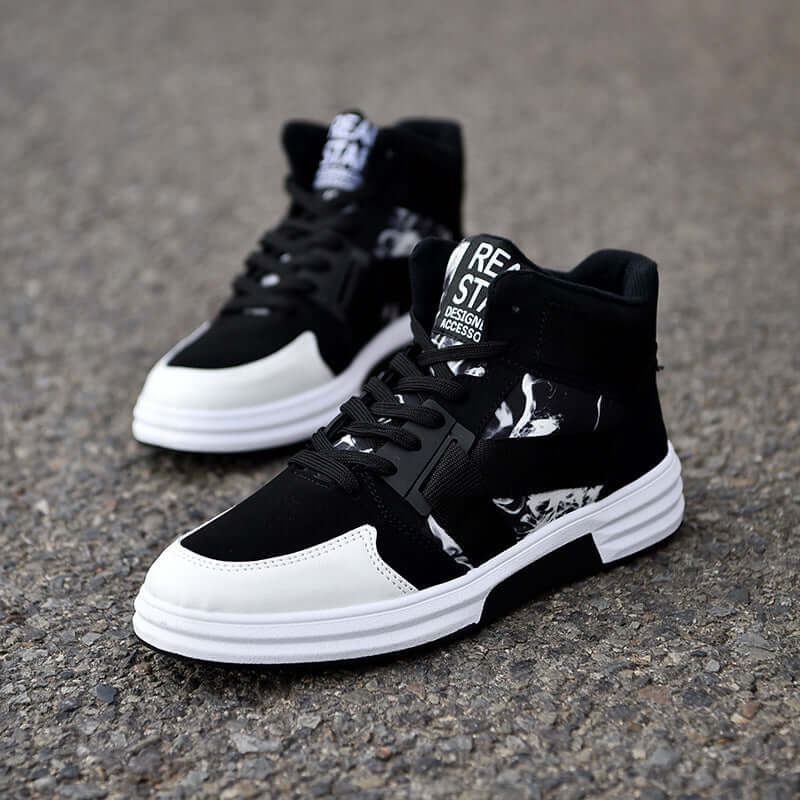 Black and white sneakers on a gray pavement