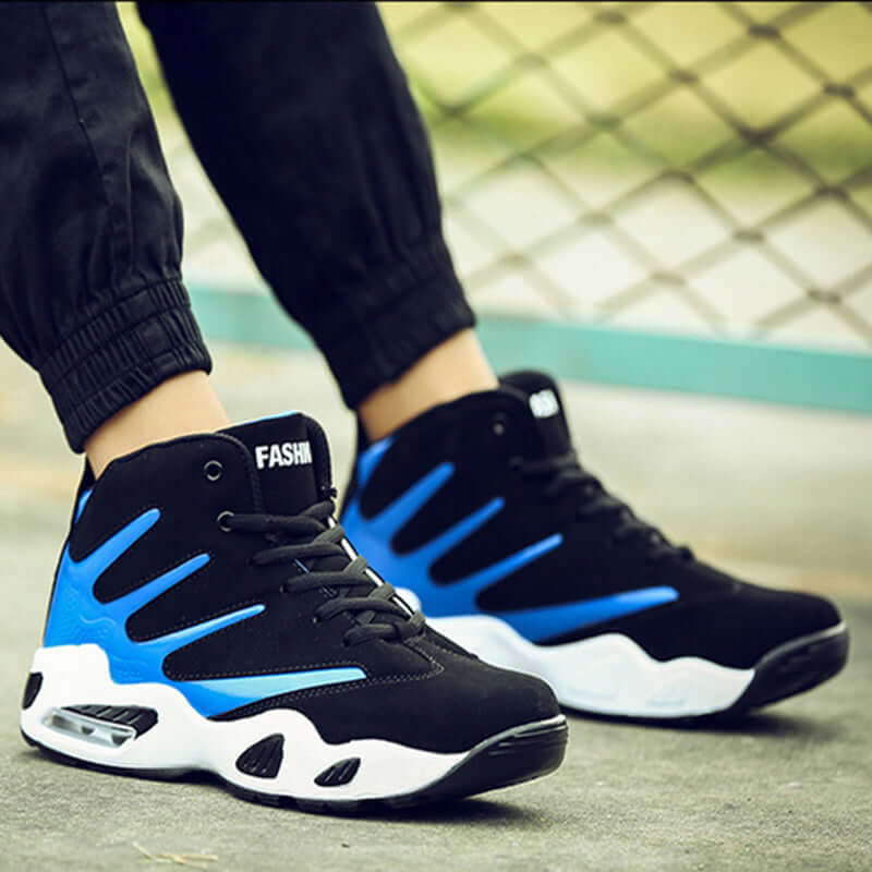 Black and blue high-top sneakers with 'FASHION' branding on a blurred outdoor background.