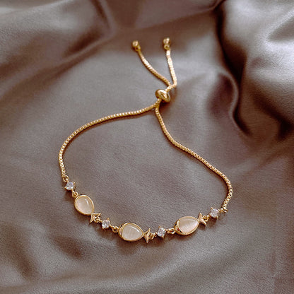 Gold bracelet with gemstones on a soft fabric background