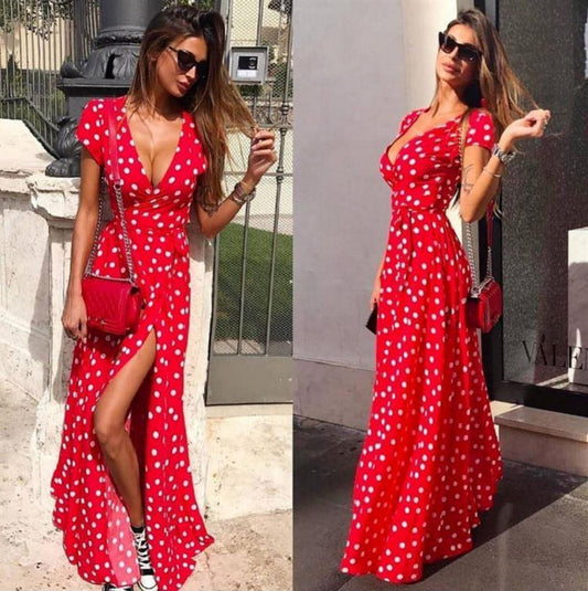 Woman wearing a red polka dot dress with a slit, posing outdoors.