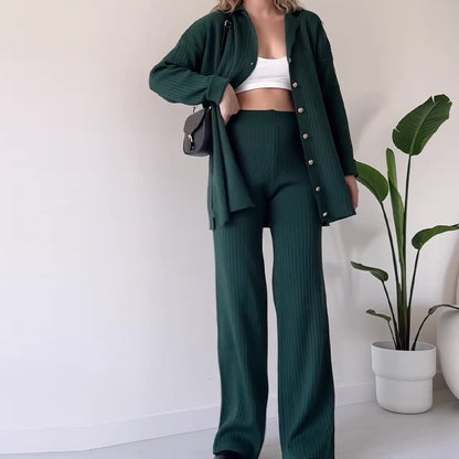 Person wearing a green outfit with a white wall and plant in the background