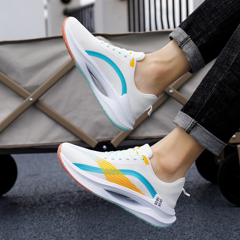 White sneakers with colorful accents worn by a person sitting on a chair.