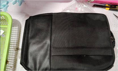 Black bag on a white surface with tools in the background
