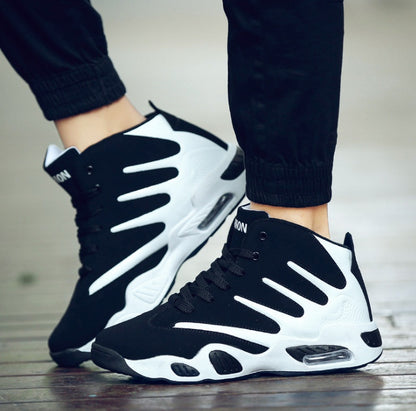 Black and white sneakers worn with black pants on a wooden floor.