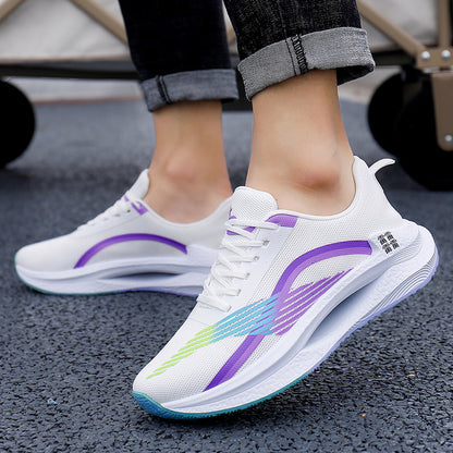 White running shoes with purple and green accents on a road surface