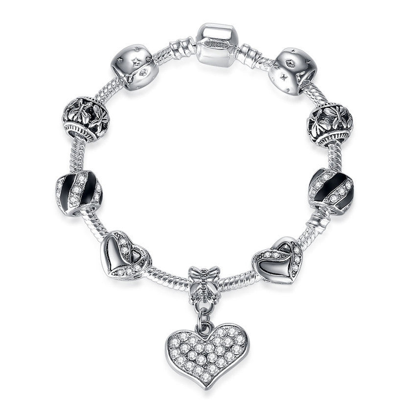 Silver bracelet with heart charm on a white background
