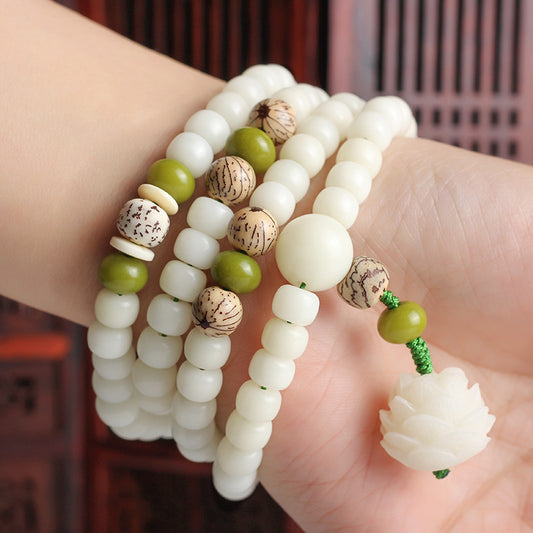 Close-up of a hand wearing multiple beaded bracelets with a blurred background