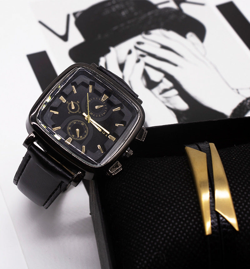Black and gold watch on a white surface with a black and white background