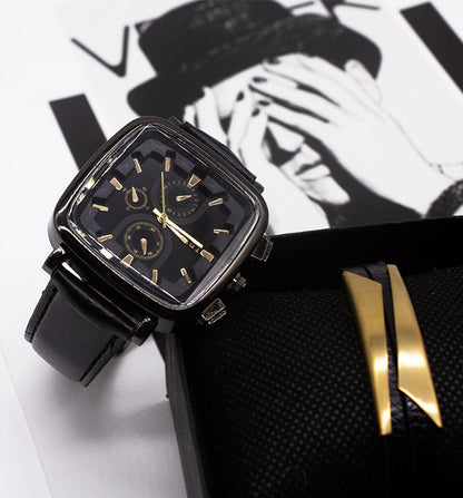 Black and gold watch on a white surface with a black and white background