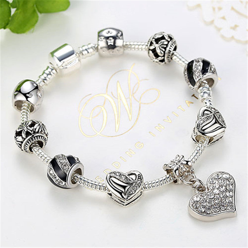 Silver bracelet with heart-shaped charms on a white background