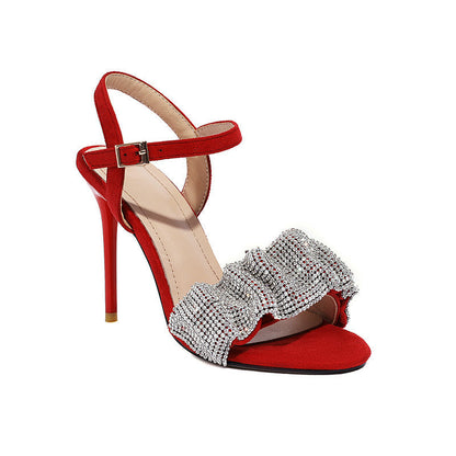 Red high-heeled sandal with a decorative bow on a white background