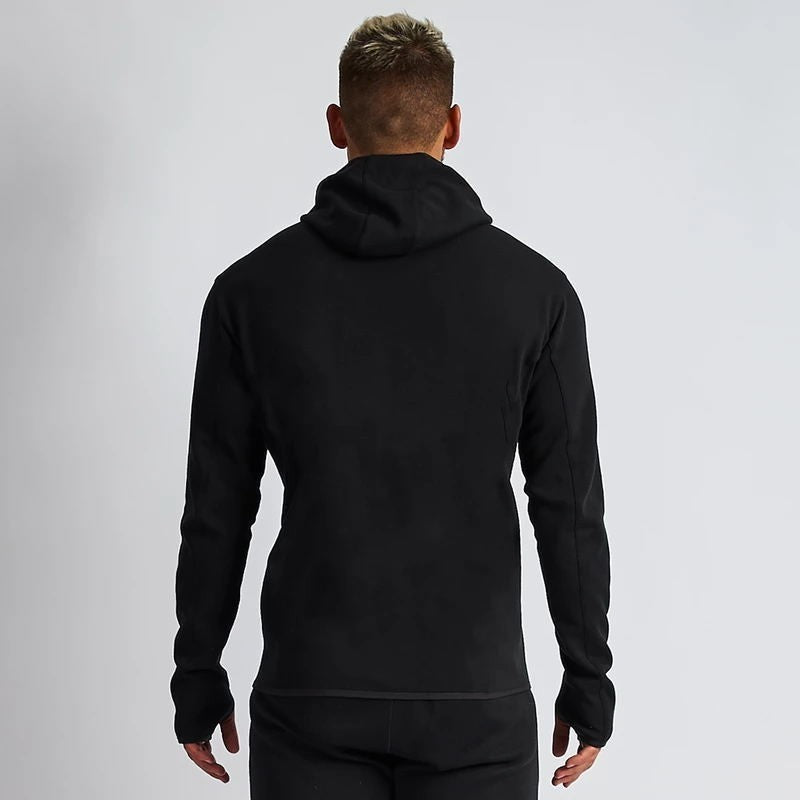 Person wearing a black hoodie from behind on a light gray background